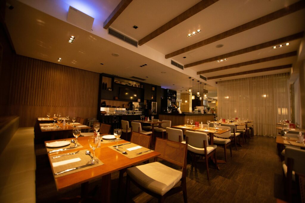 A modern restaurant interior with elegant table settings and warm ambiance, ready for guests.