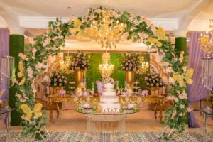 Sophisticated quinceañera celebration featuring floral arches and chandeliers.